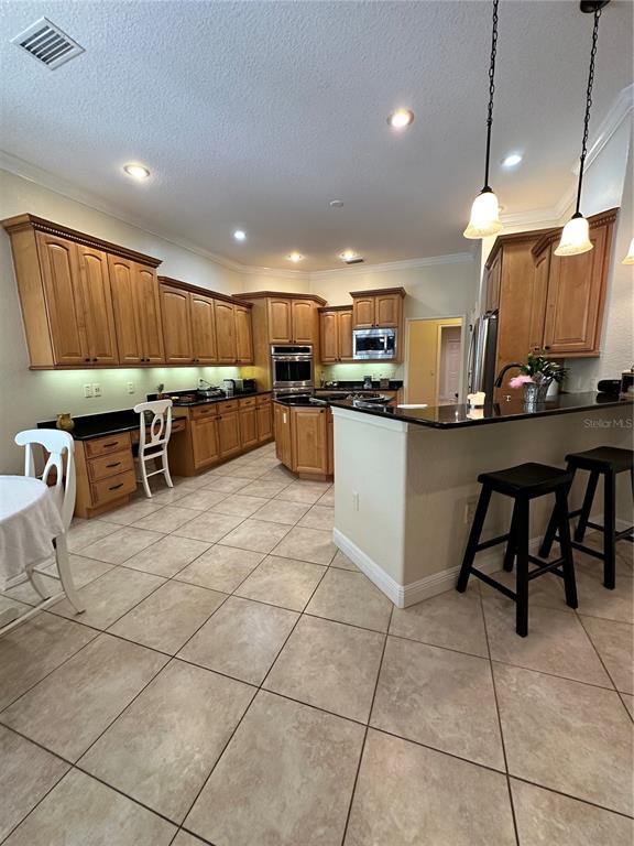 8209 Southwest 196th Ct Road Dunnellon, FL 34432 - Photo 11 of 29 a kitchen with stainless steel appliances kitchen island granite countertop a table chairs and a sink