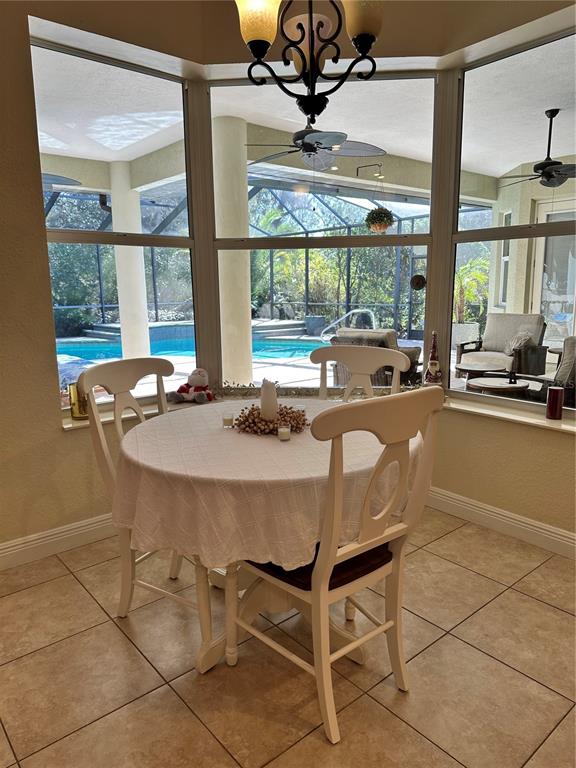8209 Southwest 196th Ct Road Dunnellon, FL 34432 - Photo 9 of 29 a dining room with furniture a large window and a chandelier
