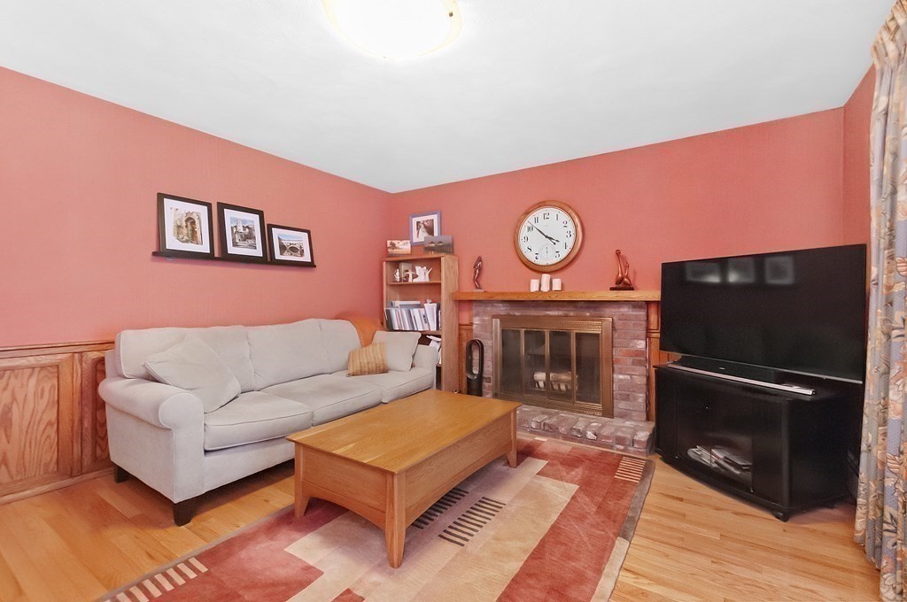 17 Nardone Road Needham, MA 02492 - Photo 9 of 22 a living room with furniture a flat screen tv and a fireplace with a bookshelf