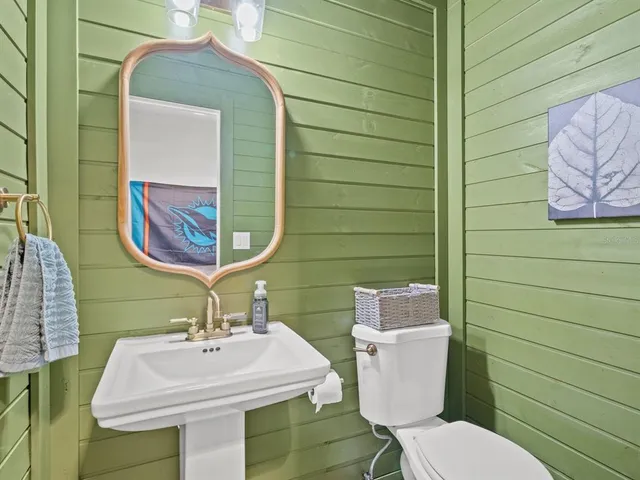 a bathroom with a sink mirror and toilet