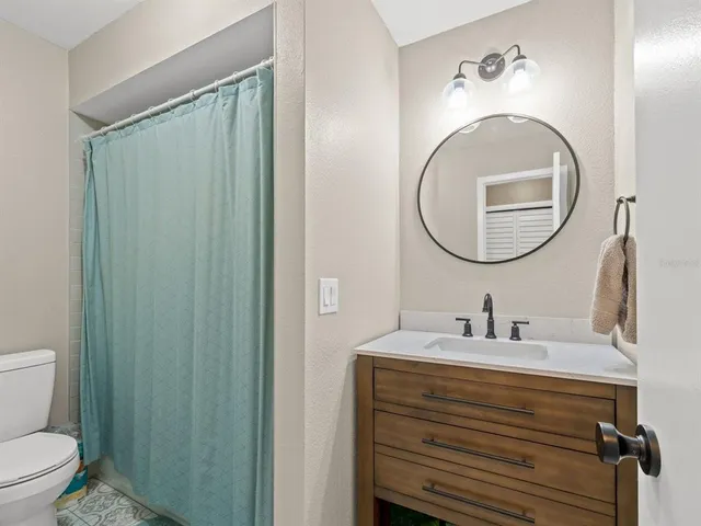 a bathroom with a sink a toilet and a mirror