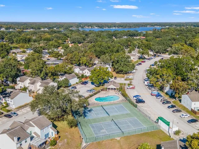 an aerial view of residential houses with outdoor space and trees