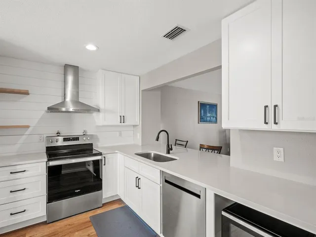 a kitchen with granite countertop a sink stove and cabinets