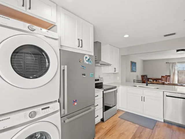 a kitchen with white cabinets and white appliances