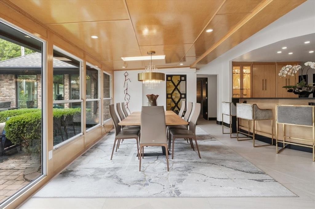 308 North Broadway Road Azle, TX 76020 - Photo 11 of 31 The dining area features a large table with seating for eight, a gold-toned chandelier, and expansive windows providing views of the exterior brickwork and landscaping