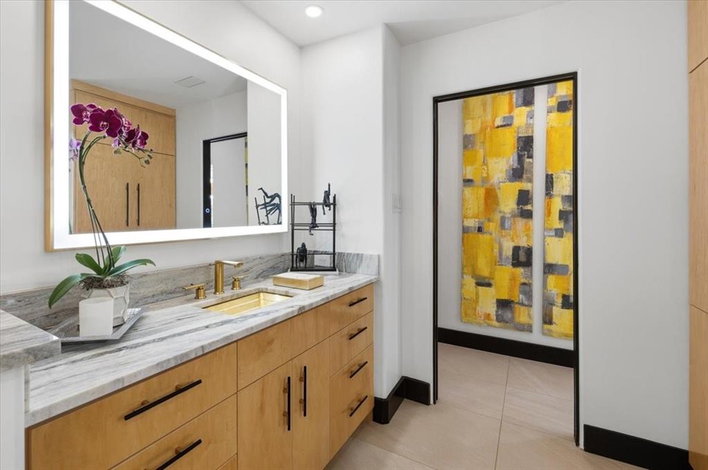 308 North Broadway Road Azle, TX 76020 - Photo 14 of 31 Elegant features a vanity with a light wood finish, a gray marble countertop, and a golden sink and faucet