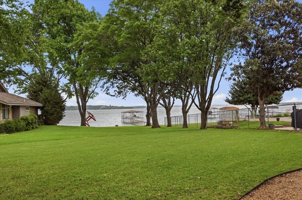 308 North Broadway Road Azle, TX 76020 - Photo 27 of 31 Expansive lawn with mature trees, offering views of the lake and a private dock