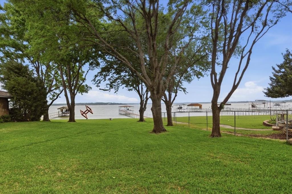 308 North Broadway Road Azle, TX 76020 - Photo 28 of 31 The property features a spacious lawn with mature trees and direct water views, including various docks and boat slips