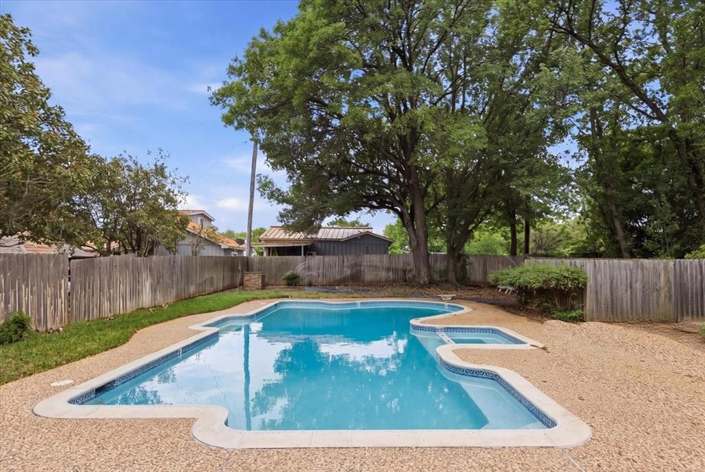308 North Broadway Road Azle, TX 76020 - Photo 31 of 31 The community swimming pool with an integrated spa, surrounded by anaggregate-finish deck