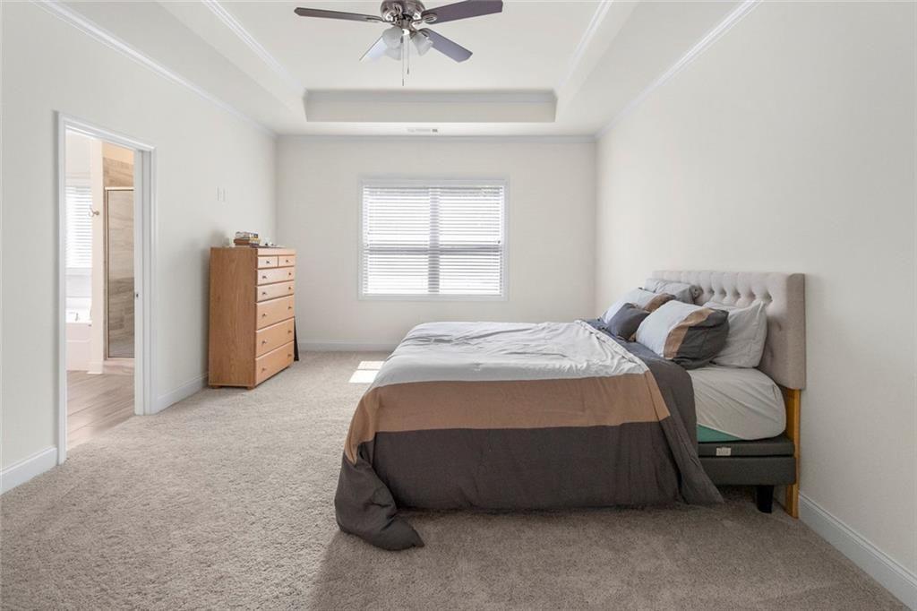 5437 Maple Grv Lane Flowery Branch, GA 30542 - Photo 23 of 27 a spacious bedroom with a bed and a chandelier
