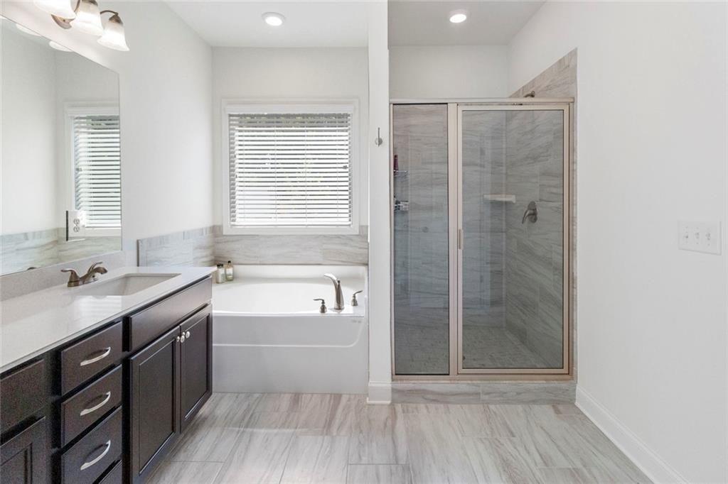 5437 Maple Grv Lane Flowery Branch, GA 30542 - Photo 26 of 27 a bathroom with a tub sink shower and a mirror