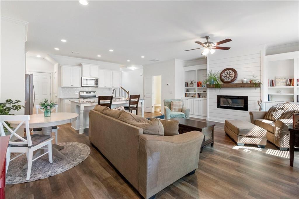 5437 Maple Grv Lane Flowery Branch, GA 30542 - Photo 6 of 27 a living room with furniture a clock and a fireplace