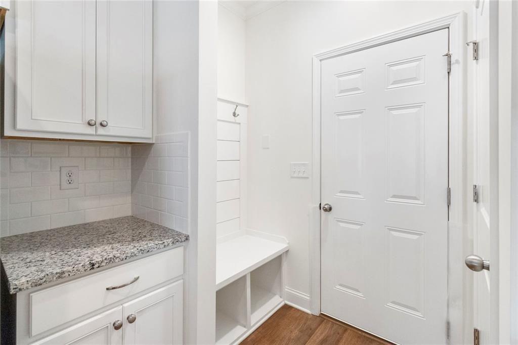 5437 Maple Grv Lane Flowery Branch, GA 30542 - Photo 8 of 27 a view of a kitchen with white cabinets and a wooden floor