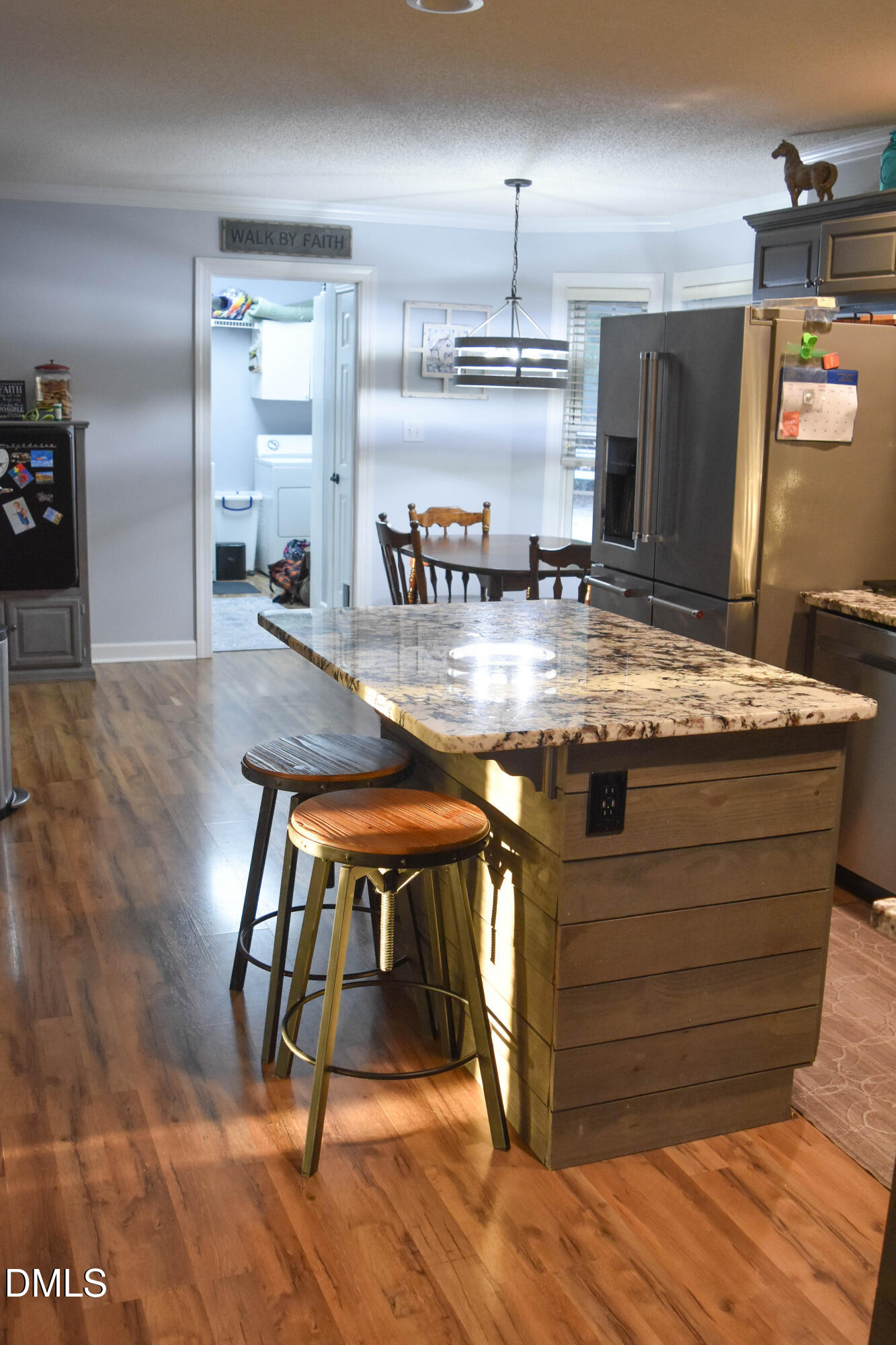 5908 Deep Spring Circle Wake Forest, NC 27587 - Photo 10 of 51 a view of a kitchen with kitchen island stainless steel appliances wooden floor dining table and chairs