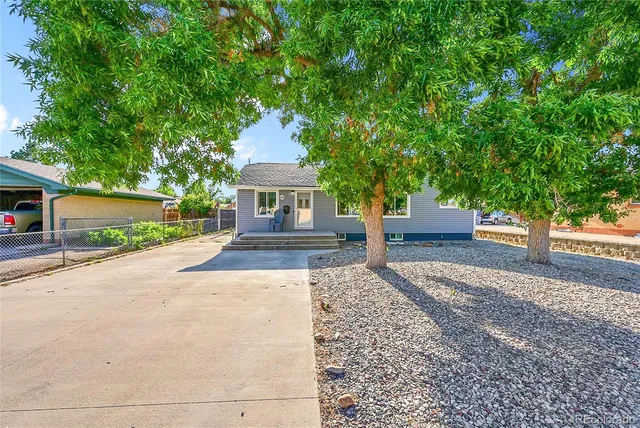 a front view of a house with a yard and trees