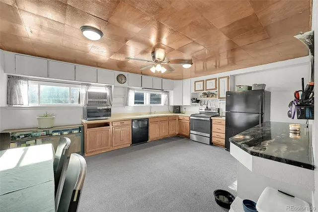 a kitchen with stainless steel appliances granite countertop a sink a stove and a refrigerator