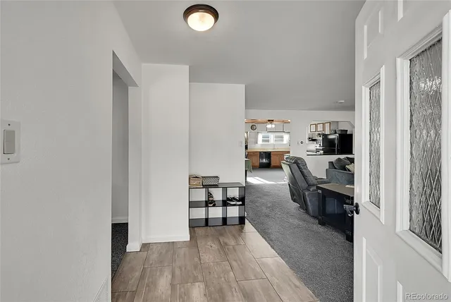 a living room with stainless steel appliances furniture and a view of kitchen