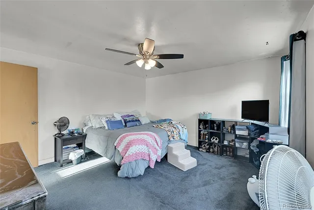 a bedroom with bed a chair and a chandelier