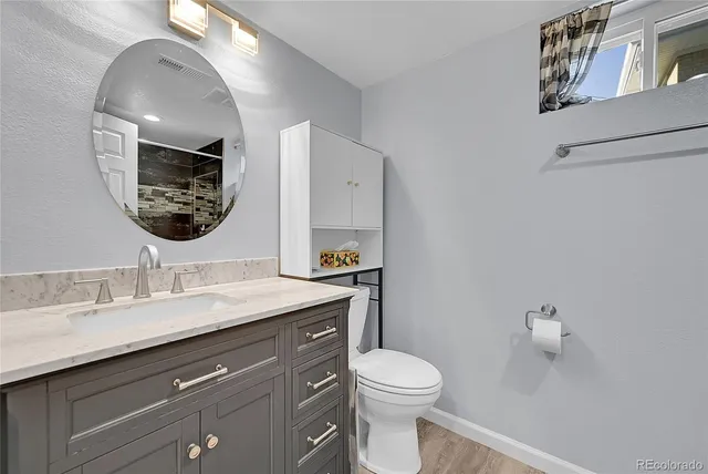 a bathroom with a toilet a sink and mirror