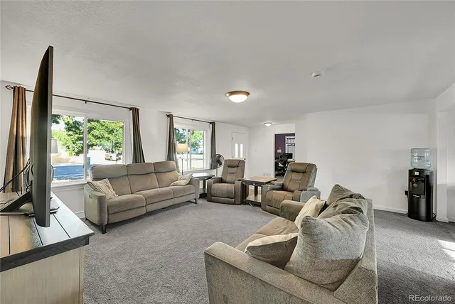 a living room with furniture window and a flat screen tv