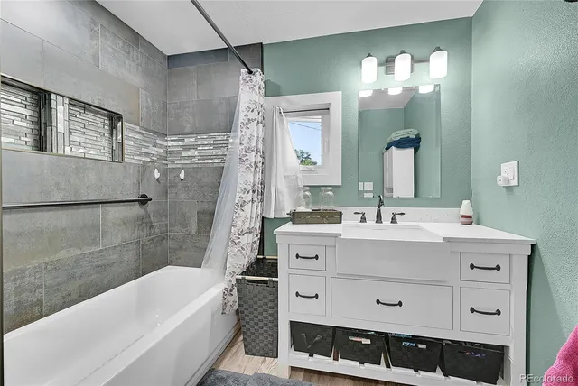a bathroom with a double vanity sink mirror and bathtub