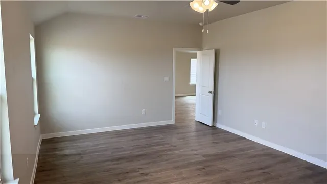 a view of a room with wooden floor and a chandelier fan