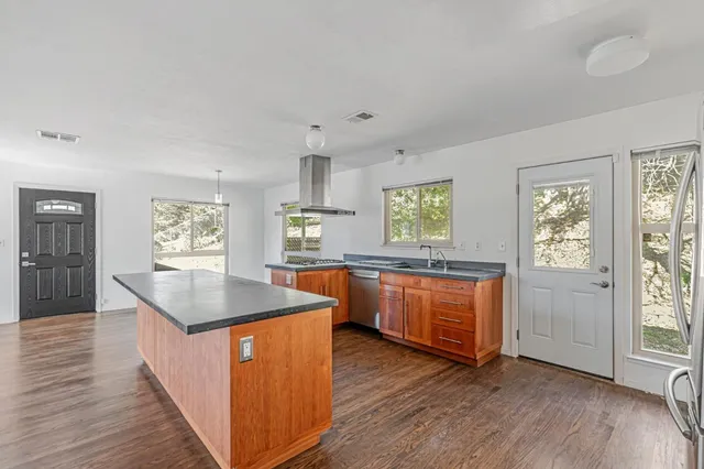 a kitchen with wooden floors and window