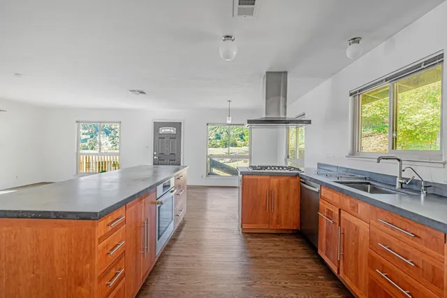 a kitchen with stainless steel appliances granite countertop a sink stove and refrigerator