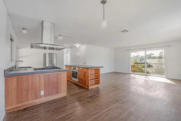 a large kitchen with stainless steel appliances granite countertop a stove a sink and a wooden floors