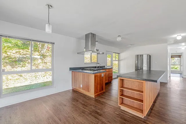 a kitchen with stainless steel appliances granite countertop a stove a sink and a wooden floors