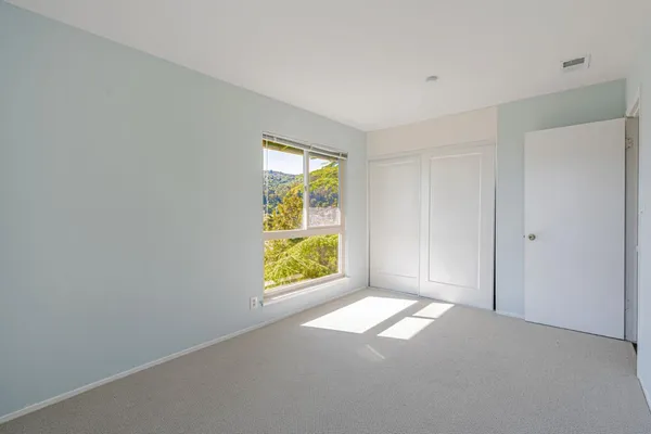an empty room with windows and mirror