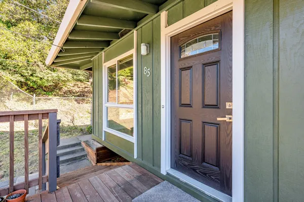 a view of front door deck and wooden floor
