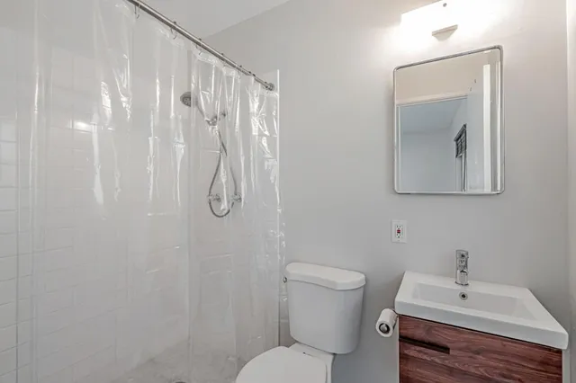a bathroom with a sink a toilet and shower