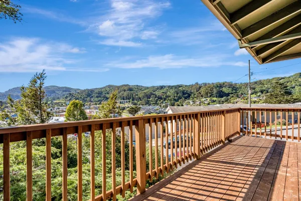 a balcony with wooden floor and city view