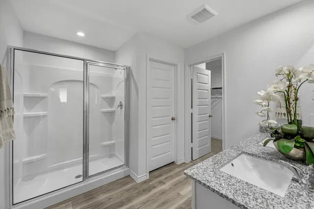 a bathroom with a granite countertop sink and shower