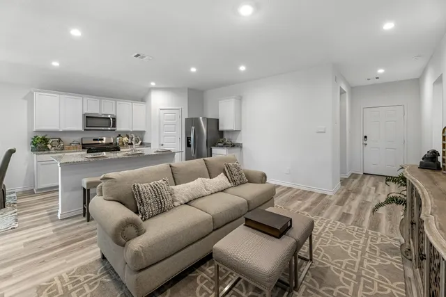 a living room with furniture and kitchen view