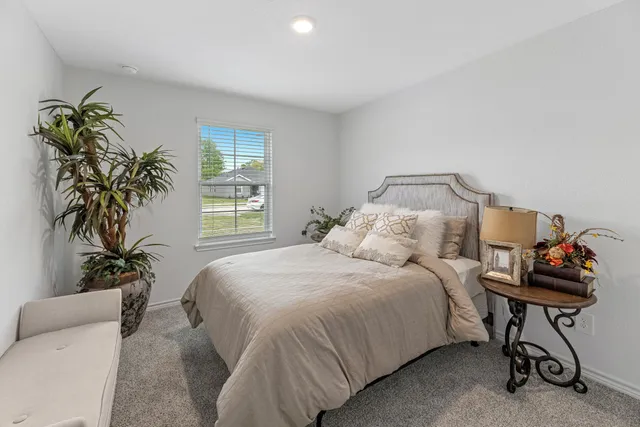 a bedroom with a bed and a potted plant