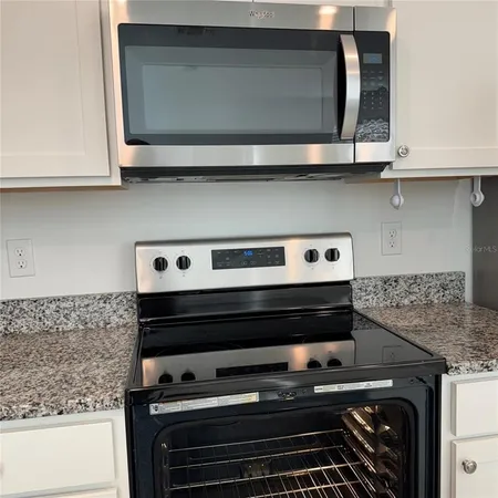a stove top oven sitting inside of a kitchen