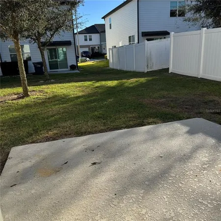 a view of a house with backyard and trees