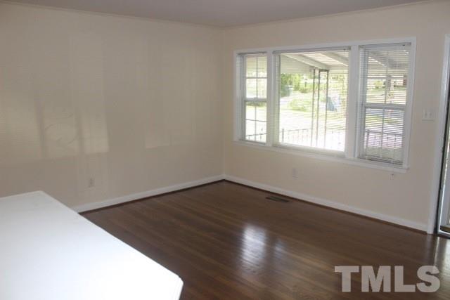 800 Friar Tuck Road Raleigh, NC 27610 - Photo 4 of 18 an empty room with wooden floor and windows