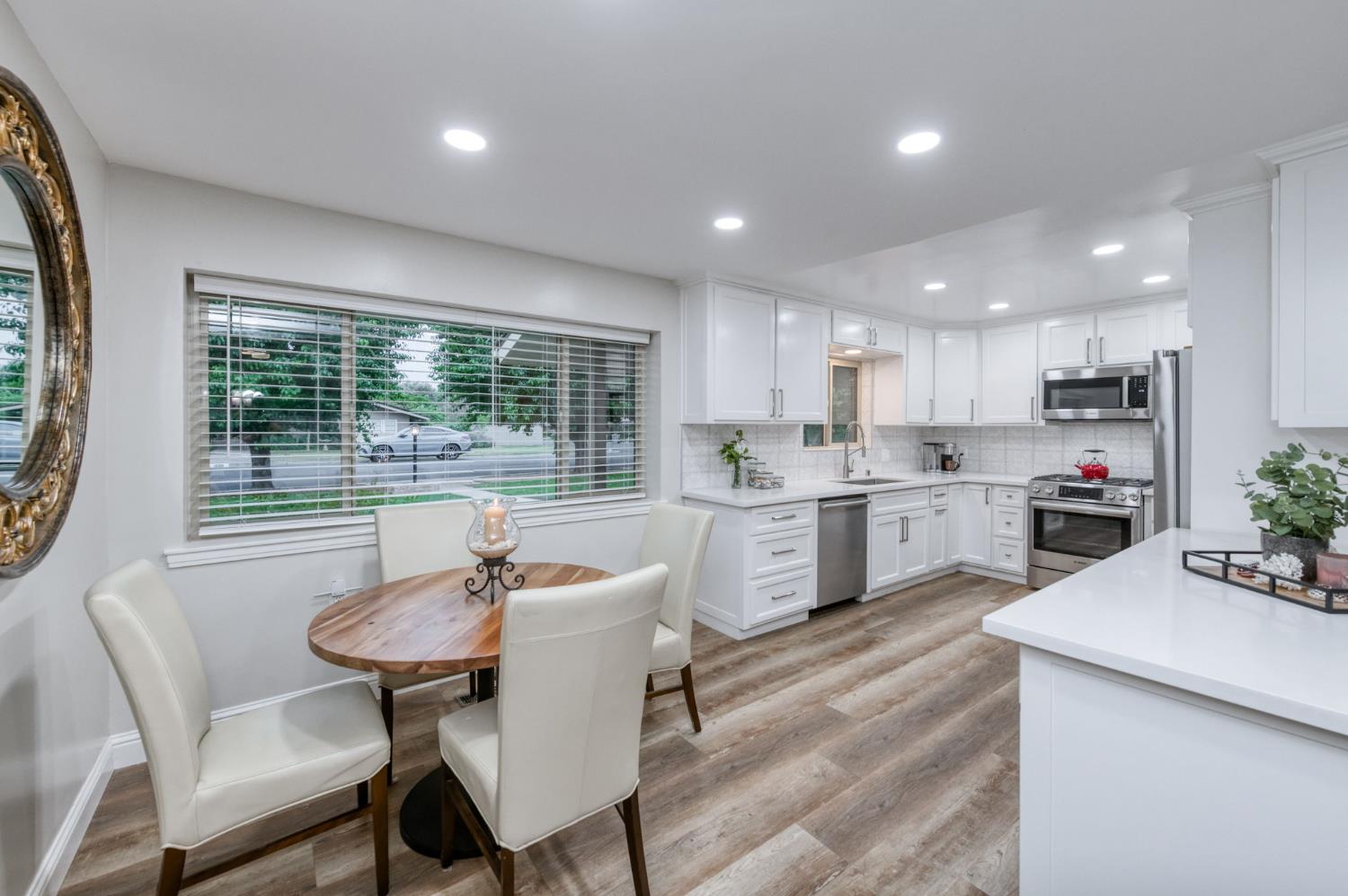 1540 West San Ramon Avenue Fresno, CA 93711 - Photo 13 of 32 a kitchen with a table chairs sink and cabinets