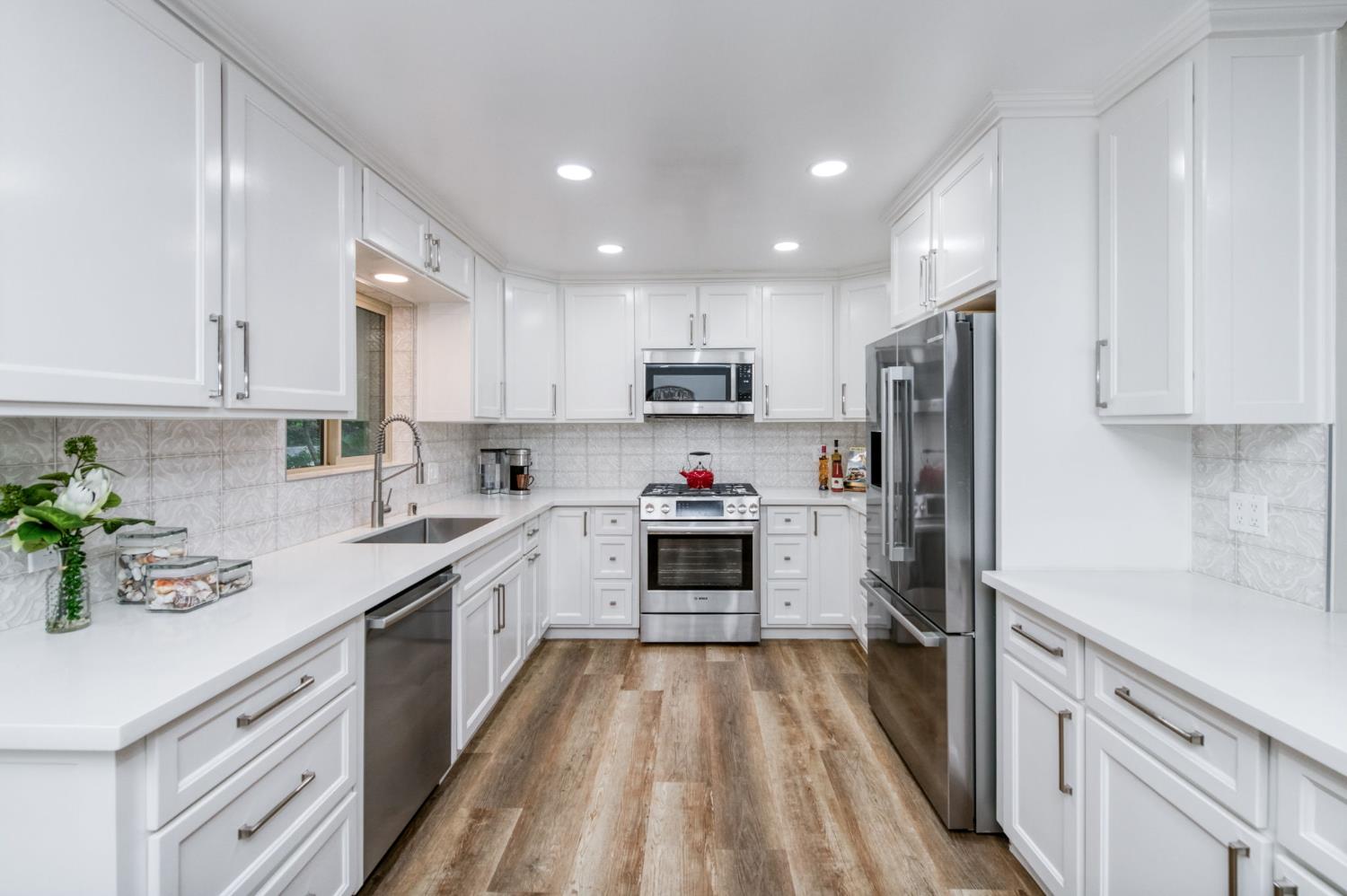1540 West San Ramon Avenue Fresno, CA 93711 - Photo 14 of 32 a kitchen with a refrigerator a sink a stove top oven and white cabinets