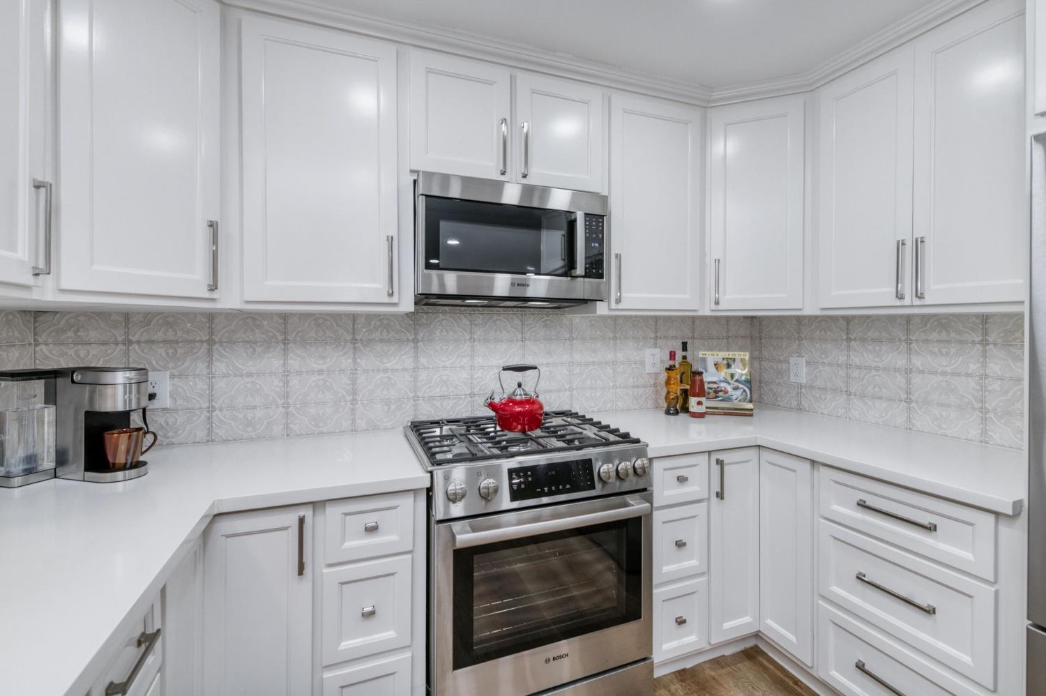 1540 West San Ramon Avenue Fresno, CA 93711 - Photo 15 of 32 a kitchen with stainless steel appliances granite countertop white cabinets a stove a sink and dishwasher