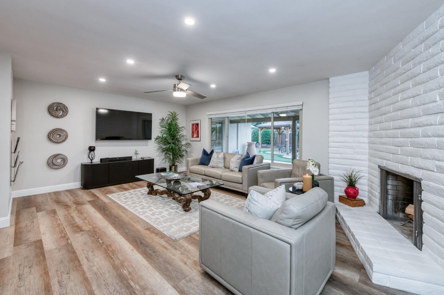 1540 West San Ramon Avenue Fresno, CA 93711 - Photo 7 of 32 a living room with furniture a fireplace and a flat screen tv
