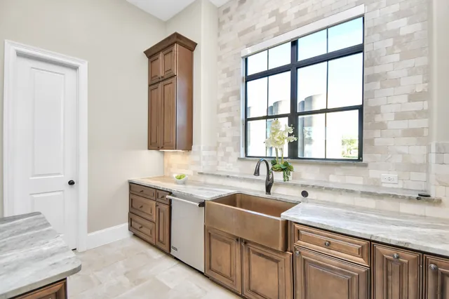 a kitchen with granite countertop a stove oven and white cabinets