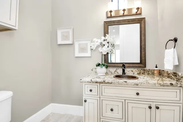 a bathroom with a granite countertop sink toilet a large mirror a shower and a bathtub
