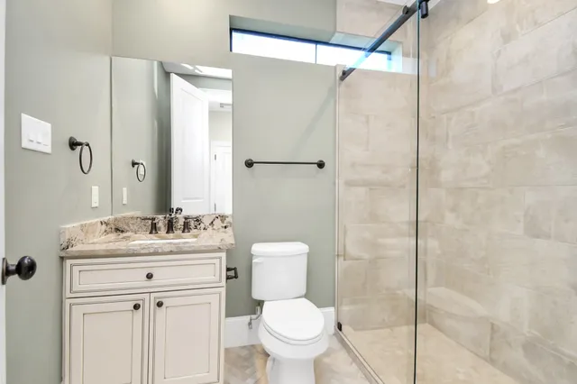 an empty room with windows and ceiling fan