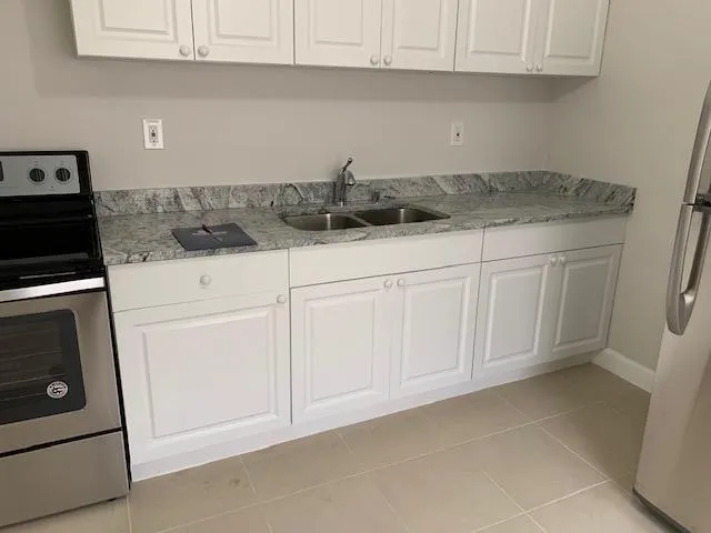 a kitchen with white cabinets and white appliances