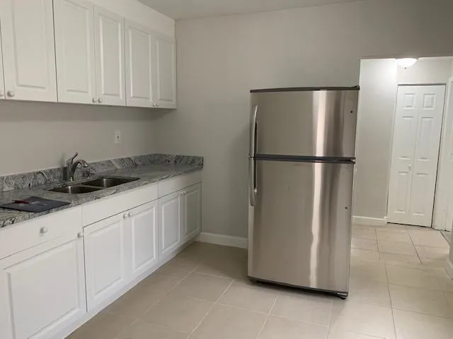 a kitchen with a refrigerator sink and cabinets