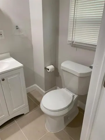 a white toilet sitting next to a sink and vanity